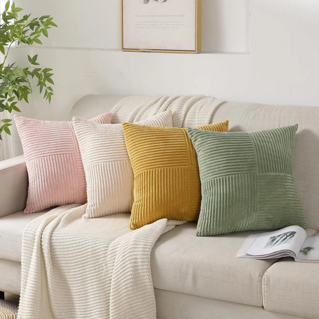 Beige sofa with colorful pillows and a plant in the corner